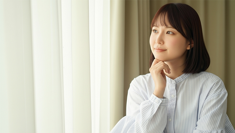 カーテンを見つめる女性